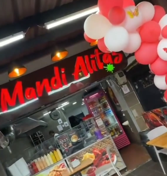 El letrero de neón de Mandi Alitas sobre el mostrador del local en La Salle